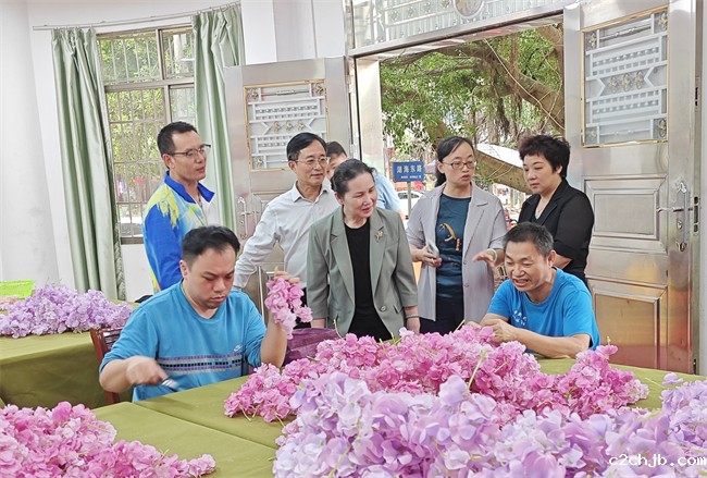 图为许英凤(中)看望在北海市辅助性就业机构就业的残疾人